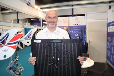 Sales-Manager-Stuart-James-holds-new-Spectra-Zipperflex-100W-solar-panels-11-29-25-1
